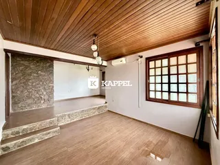 Ambiente interno com piso de madeira e escadaria em um imóvel.