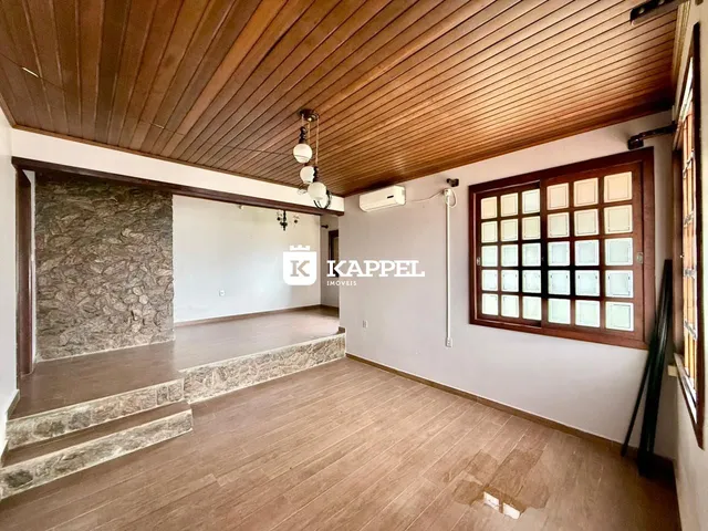 Ambiente interno com piso de madeira e escadaria em um imóvel.