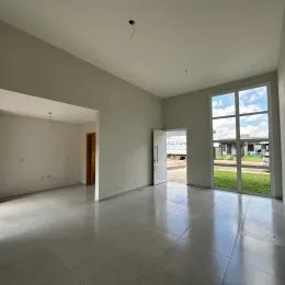 Foto de um espaço interno amplo com paredes claras e uma grande janela.