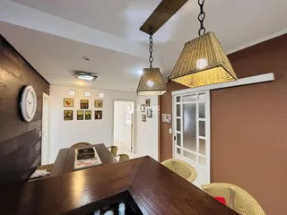 Interior de uma sala com mesa de jantar de madeira e decoração de parede.