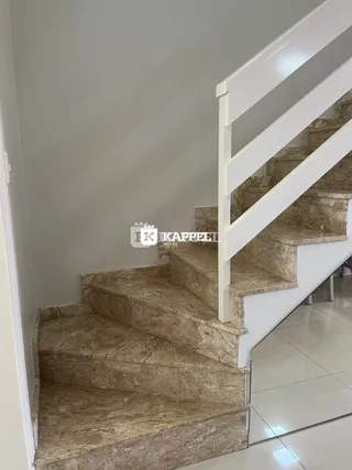 Foto de uma escadaria com degraus de mármore claro em um interior residencial.