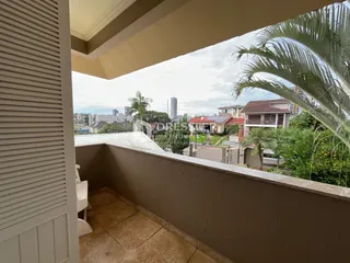Vista de um terraço com vegetação e edifícios ao fundo.