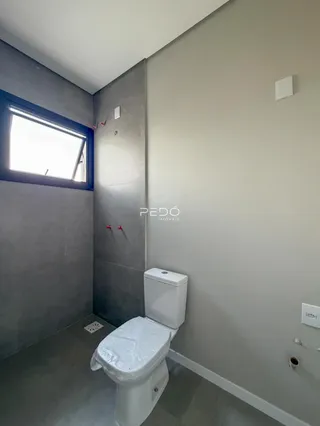 Foto de um banheiro com paredes cinzas e piso de concreto.