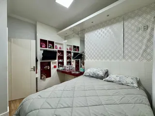 Quarto com cama grande e painel decorativo na parede branca.