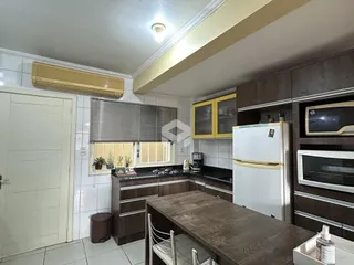 Foto de uma cozinha com armários e eletrodomésticos em um imóvel no Brasil.