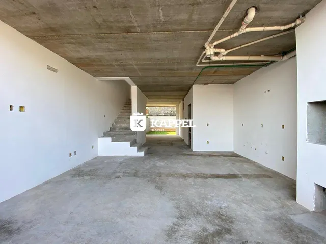 Corredor interno com paredes brancas e teto de concreto aparente.