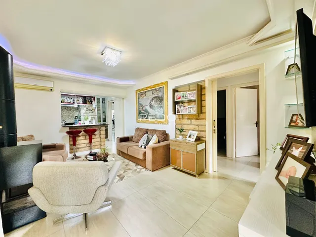 Sala de estar com lareira e piso de madeira clara.