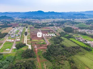 Vista aérea de uma propriedade rural com campos e vegetação.