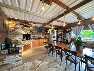 Sala de jantar com mesa de madeira e vigas de madeira expostas em um ambiente rústico.