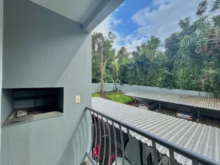 Vista da fachada de uma residência com área de estacionamento coberta.