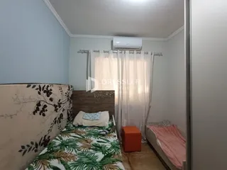 Quarto com cama e cortinas brancas.