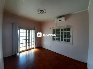 Sala de estar com piso de madeira e portas de vidro que dão acesso ao exterior.