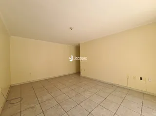 Ambiente interno de uma sala vazia com piso de cerâmica clara.