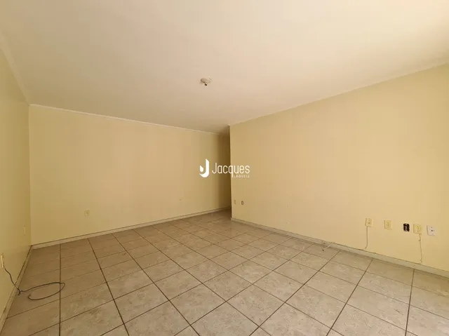 Ambiente interno de uma sala vazia com piso de cerâmica clara.