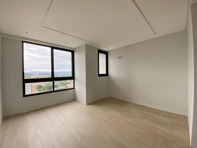 Sala de estar com grande janela oferecendo vista da paisagem urbana.
