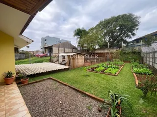 Vista externa de um jardim com gramado e cerca de madeira.