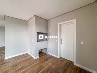 Ambiente interno com paredes cinzas e piso de madeira, apresentando uma lareira.