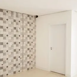Parede decorada com revestimento de azulejos em tons de cinza e branco.