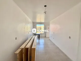 Foto de um corredor interno com paredes brancas e piso de cerâmica.