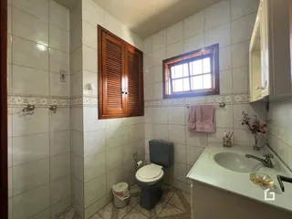 Foto de um banheiro com revestimento de cerâmica e armários de madeira.