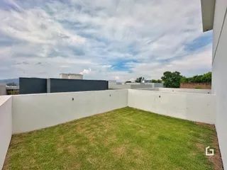 Jardim gramado cercado por muros brancos.