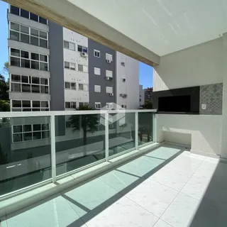 Vista da varanda com piso de cerâmica e grade de vidro.