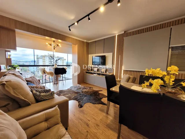 Sala de estar com vista para a cidade e piso de madeira.