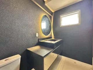 Foto de um banheiro moderno com bancada e vaso sanitário.