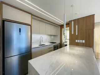 Foto de uma cozinha moderna com armários brancos e bancadas claras.