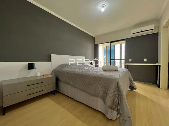 Quarto com cama grande e paredes cinzas.