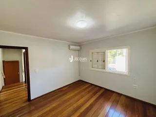 Sala de estar com piso de madeira e janela.