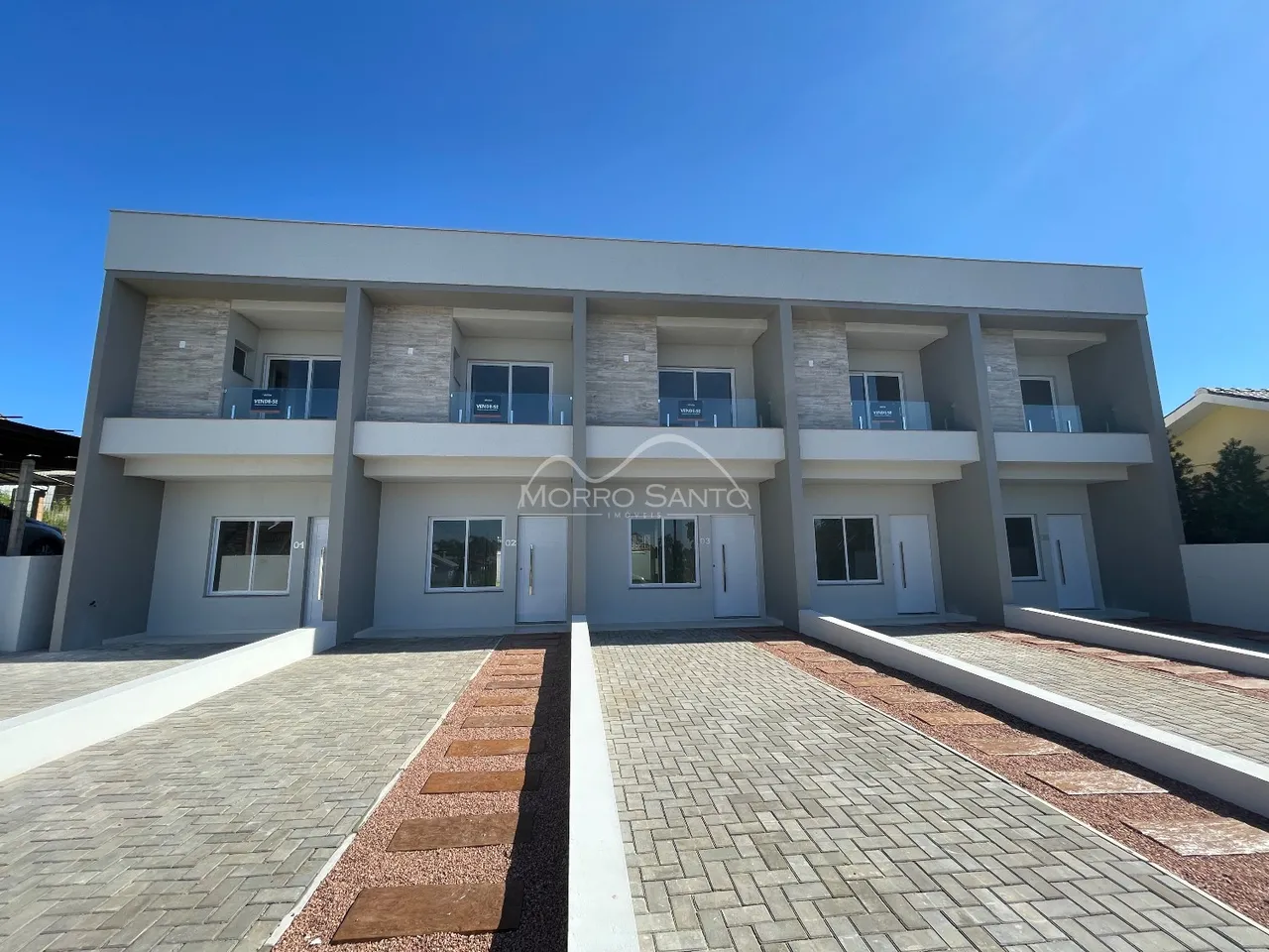 Fachada de uma casa residencial de dois andares com terraço e calçada em Lajeado.