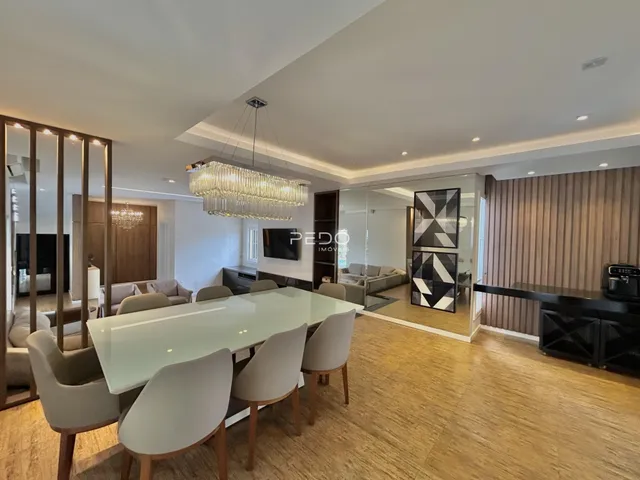 Sala de jantar e estar com piso de madeira clara.