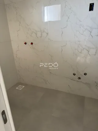 Foto de um banheiro com revestimento em mármore branco.