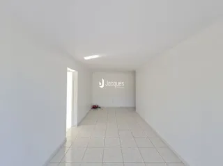 Corredor branco com piso de cerâmica.