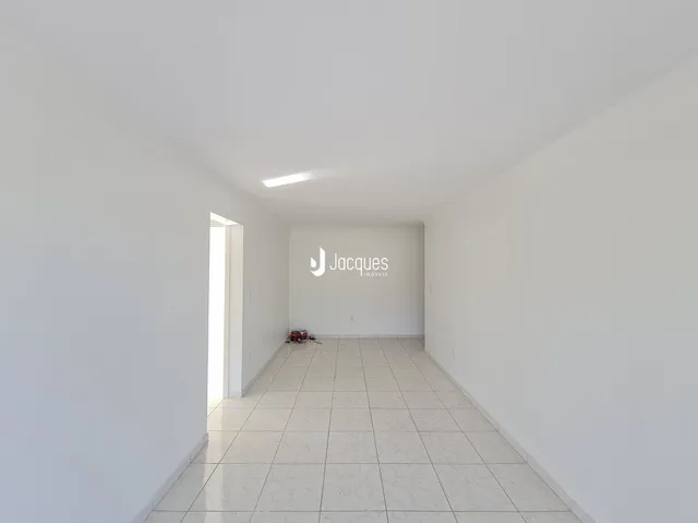 Corredor branco com piso de cerâmica.