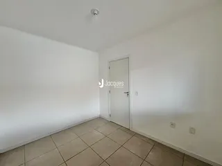 Ambiente interno de uma sala com piso de cerâmica e paredes brancas.
