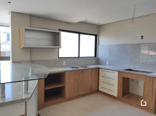 Foto de uma cozinha com armários e bancadas em um imóvel no Brasil.
