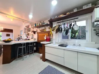 Sala de estar com cozinha integrada e luz natural.