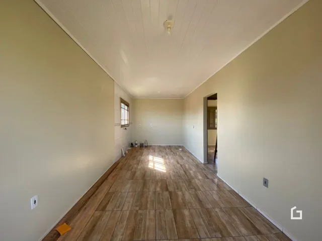 Um corredor longo com piso de madeira clara.