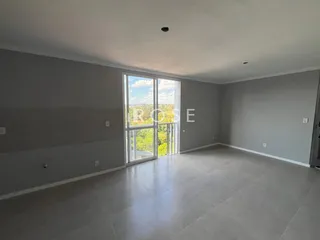 Sala de estar ampla com grande janela de vidro.