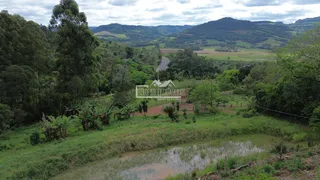 Paisagem de colinas verdes com floresta e estrada no Brasil.