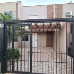 Foto da fachada de uma residência com portão de ferro na entrada.