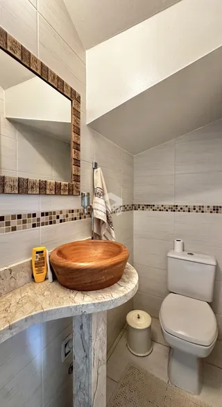 Banheiro com revestimento de azulejos brancos e marrons.