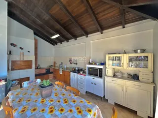 Interior da cozinha e sala de jantar com teto de madeira no imóvel.