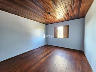 Sala de estar com piso de madeira e teto de madeira no imóvel.