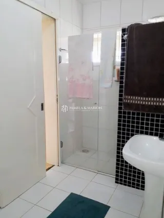 Foto de um banheiro com revestimento de cerâmica branca.