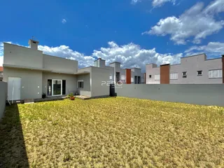 Vista externa de um conjunto de casas modernas em Lajeado, Brasil, com um terreno gramado à frente.