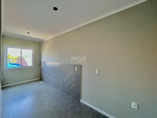 Interior de uma sala com paredes claras e piso cinza claro.
