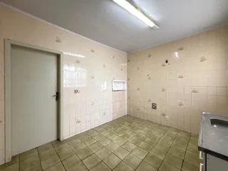 Interior de um ambiente com piso e paredes revestidos de azulejos claros.